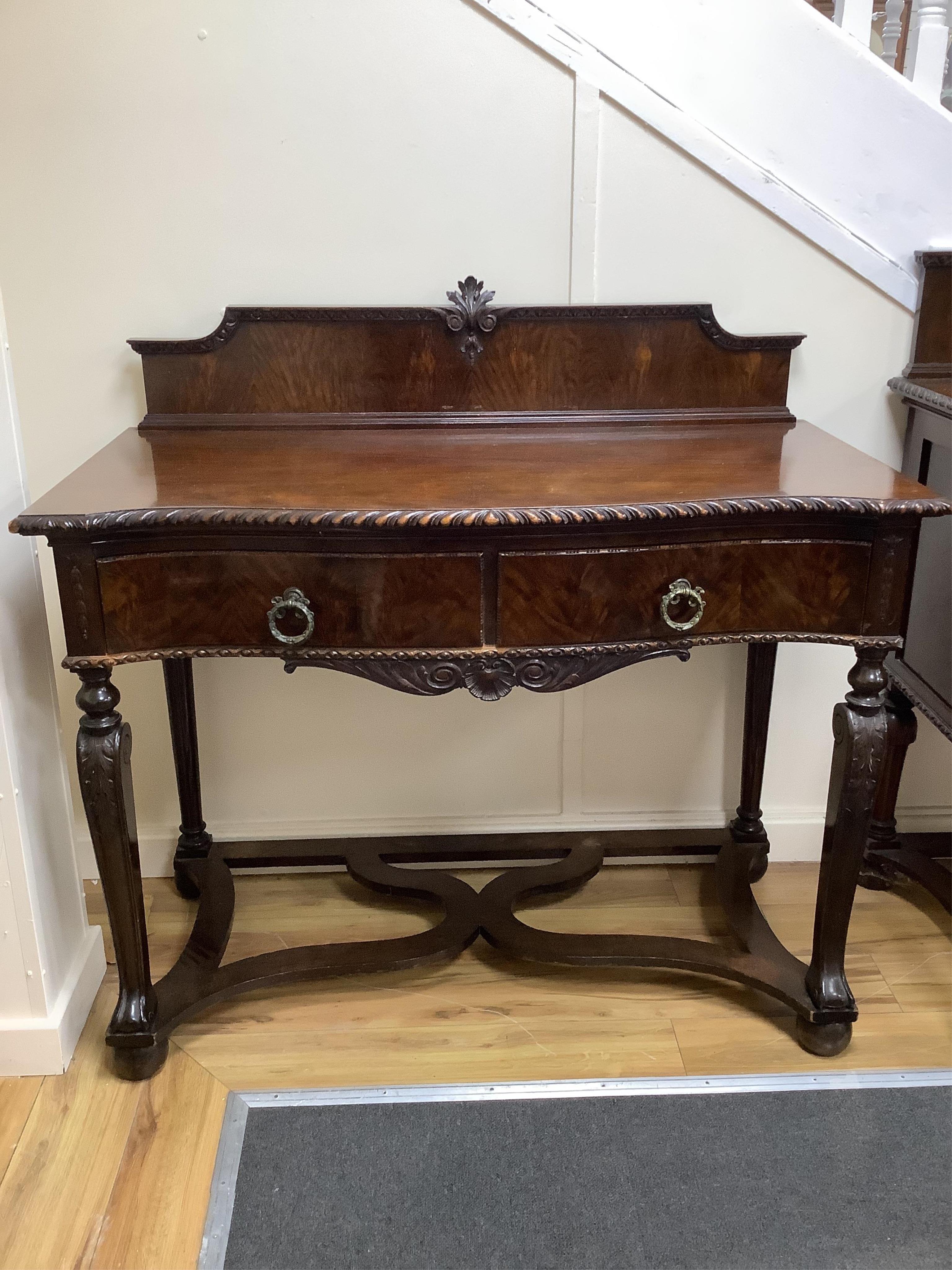 A Chippendale Revival mahogany dining suite comprising an extending dining table, width 300cm extended, depth 122cm, height 74cm, ten chairs (two with arms), a serpentine sideboard and a serving table. Condition - fair t